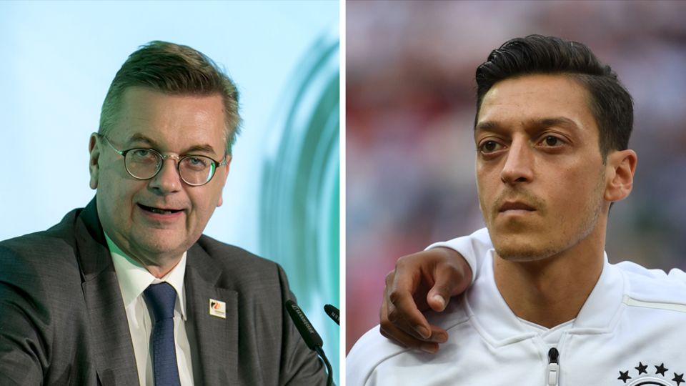 Renhard grindel Mesut Özil Links steht DFB-Präsident Reinhard Grindel an einem Rednerpult, rechts steht Mesut Özil in DFB-Trainingsjacke auf dem Platz