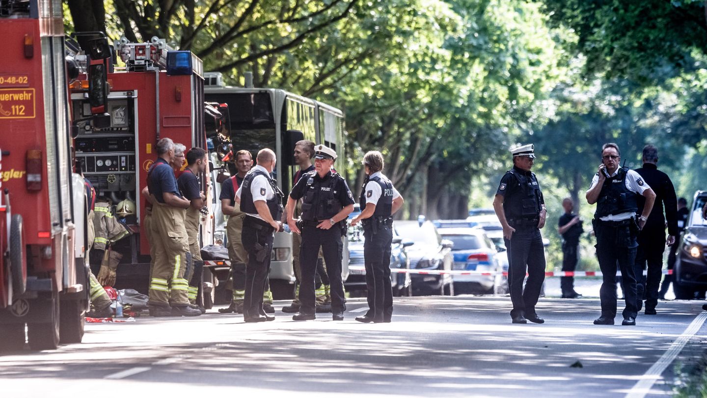 Rettungskräfte stehen nach einem Anschlag auf einen Bus auf der Straße in Lübeck
