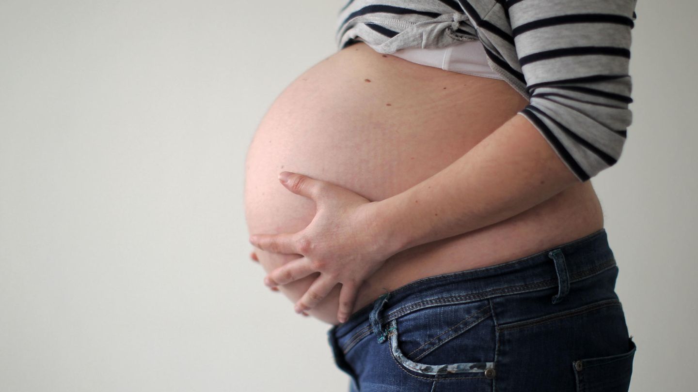 Eine schwangere Frau hält sich den Bauch