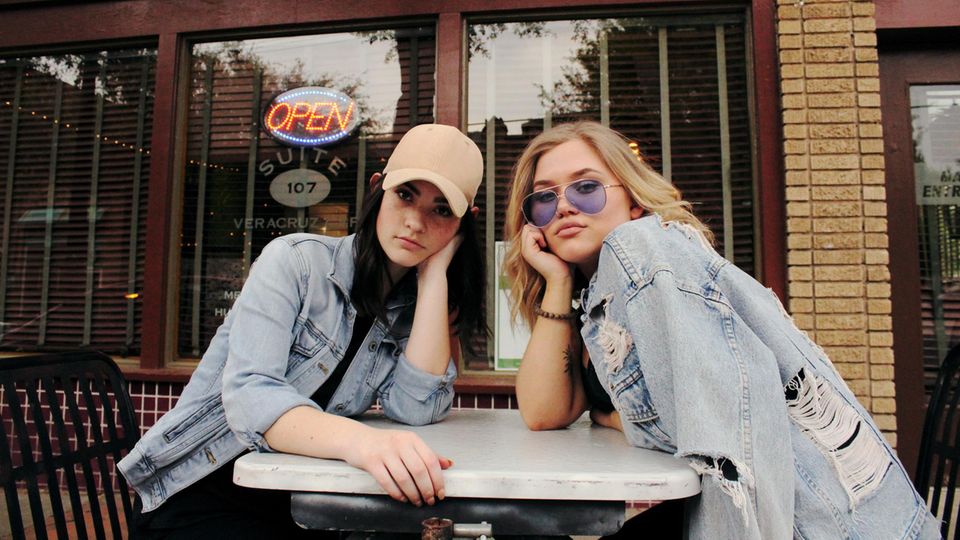 Zwei junge Millennials vor einem Restaurant
