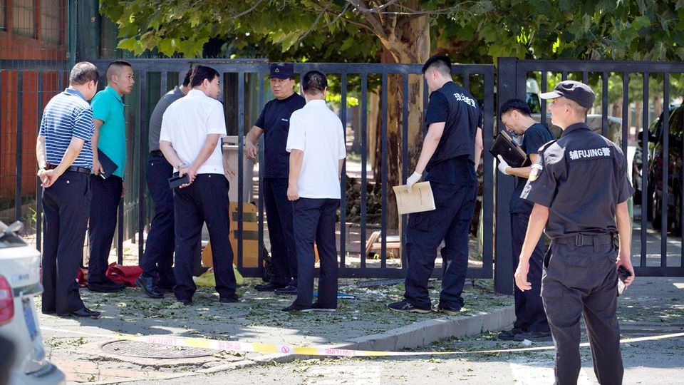 Sicherheitspersonal steht in der Nähe des Ortes der Detonation. Bei der US-Botschaft in Peking hat sich am Donnerstag eine Explosion ereignet.