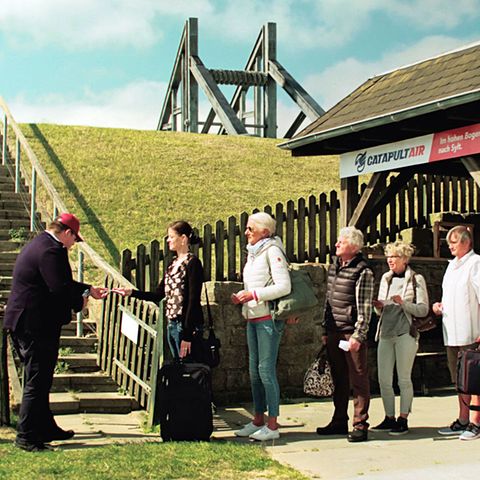 Gate am Deich: Szene aus dem Clip "Catapult Air - Im hohen Bogen nach Sylt", der auf humorvolle Weise den zweigleisigen Ausbau der Bahnstrecke nach Westland fordert.