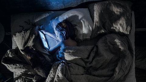Ein Junge schaut Cartoons im Bett