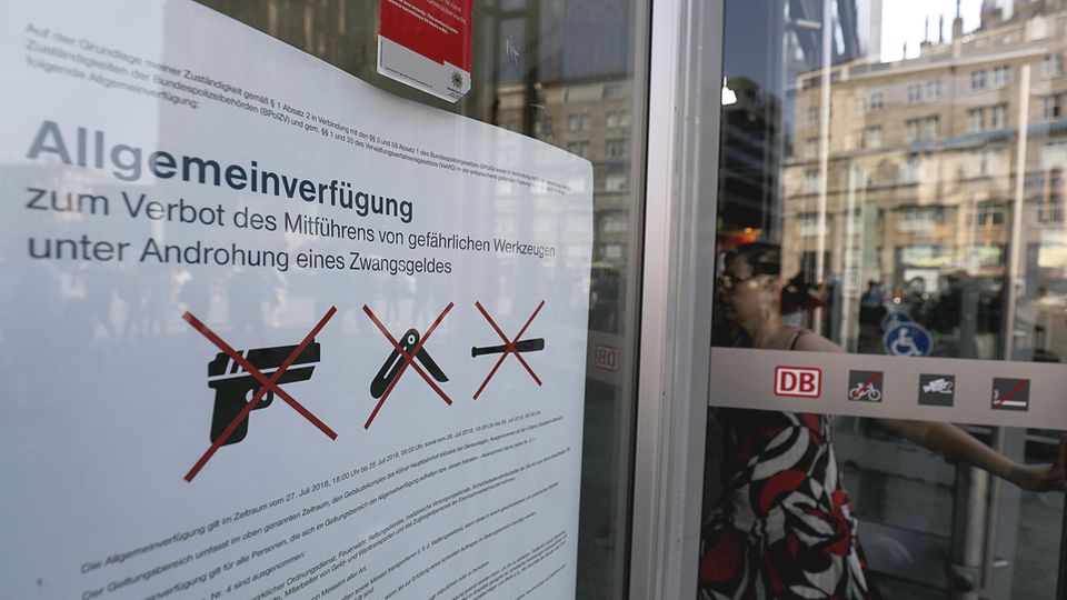 Ein Plakat am Eingang des Kölner Hauptbahnhofes informiert über das Waffenverbot im Gebäude
