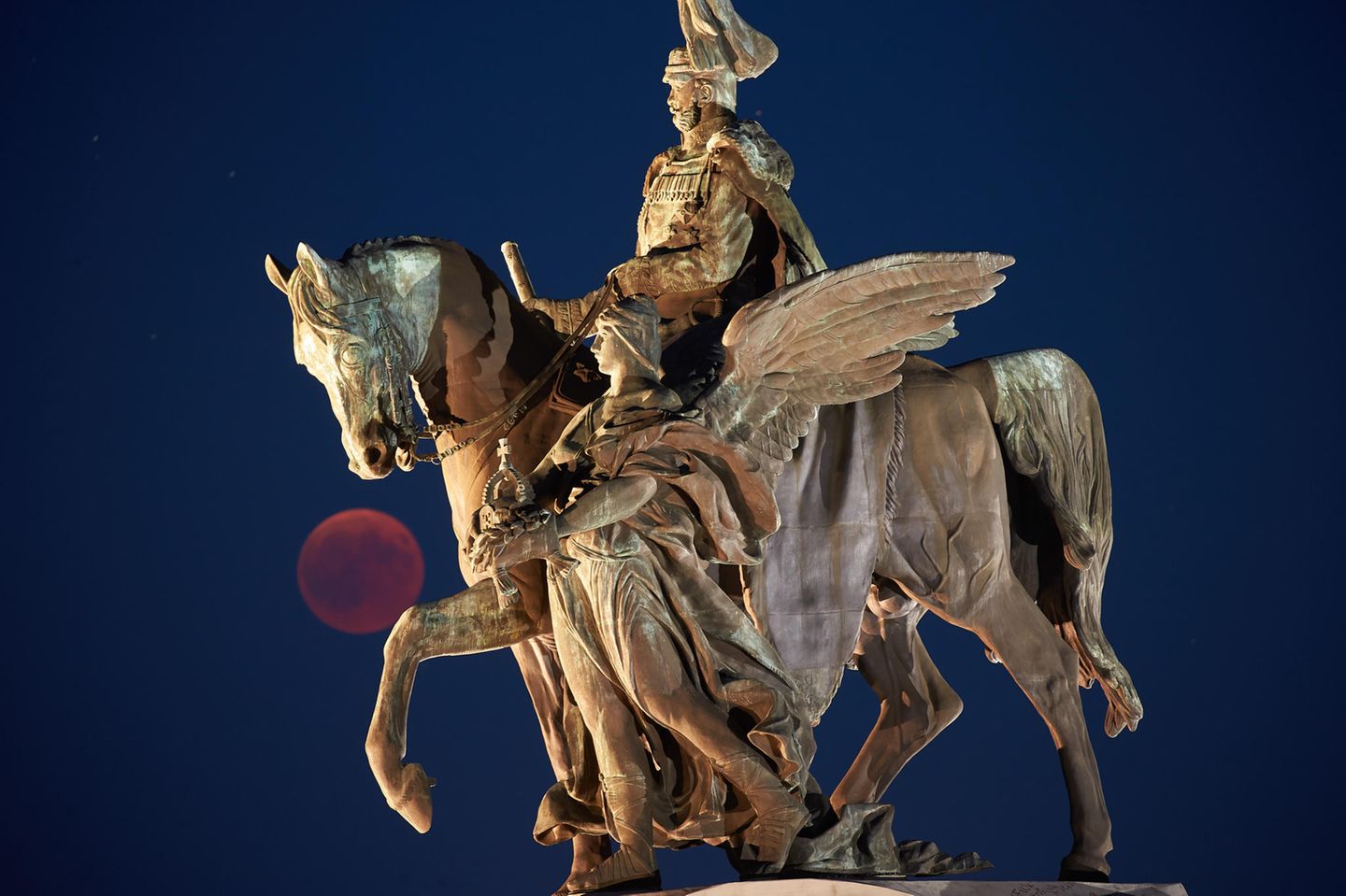 Der Vollmond ist während der Mondfinsternis am Reiterstandbild von Kaiser Wilhelm am Deutschen Eck zu sehen