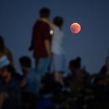 München, Bayern: Zahlreiche Menschen beobachten am Olympiaberg die Mondfinsternis mit dem rötlichen Vollmond
