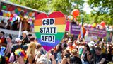 Etliche Teilnehmer waren bunt und glitzernd gekleidet, viele hielten Flaggen in Regenbogenfarben und Transparente in den in den Händen.