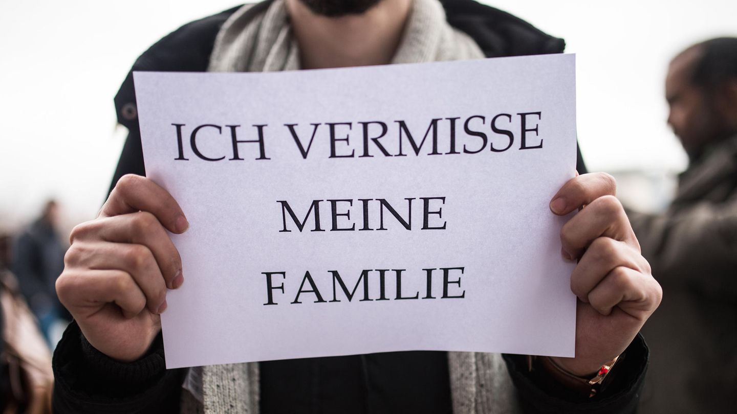 Ein Mann hält sich ein DinA4-Blatt mit dem Satz "Ich vermisse meine Familie" vor die Brust