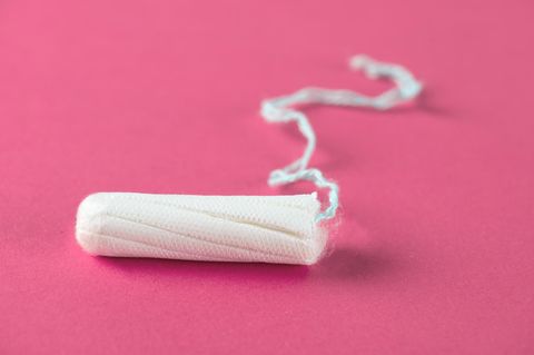 Ein Tampon liegt auf einer rosa Oberfläche
