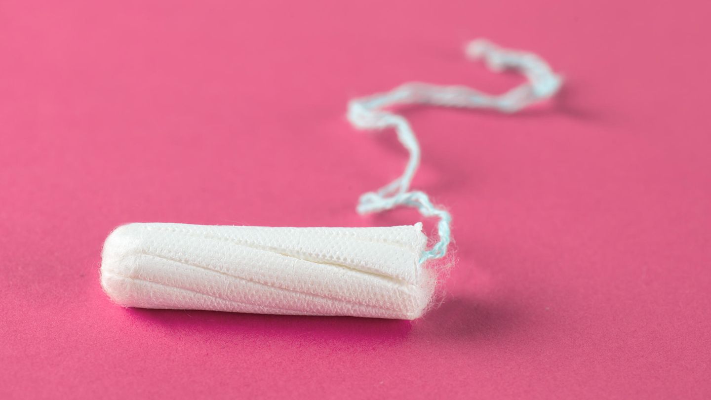 Ein Tampon liegt auf einer rosa Oberfläche
