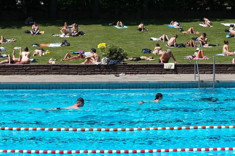 Belästigung zweier Frauen durch Männergruppe: Zu sehen ist eine Schwimmbadszene mit gefüllter Liegewiese
