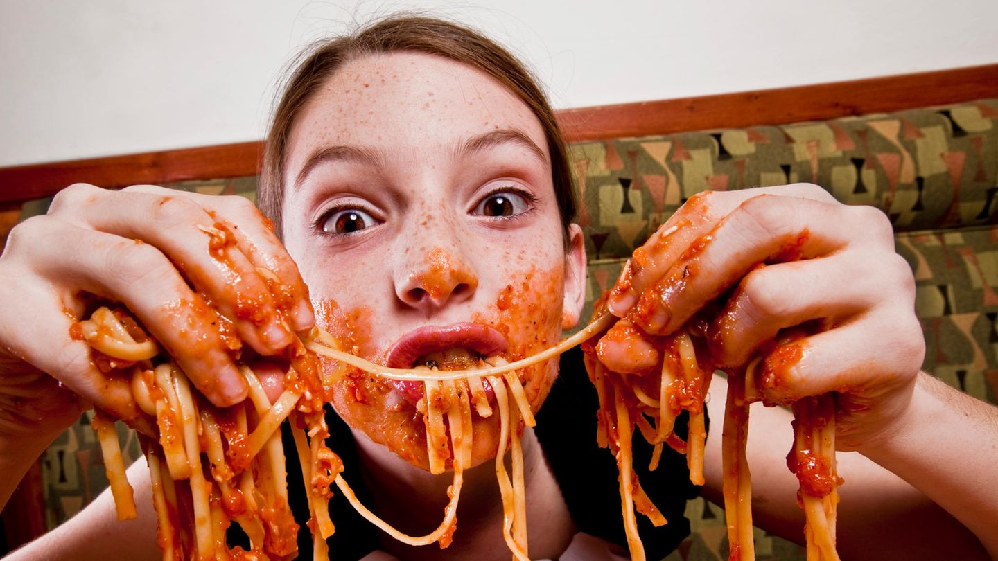 Kind isst Spaghetti mit den Händen