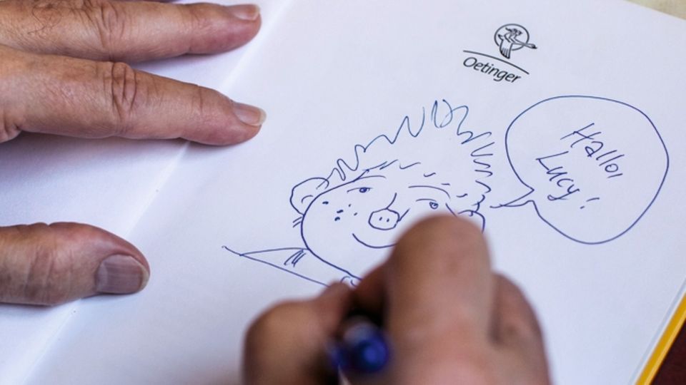 Paul Maar: Maar zeichnet das Sams in Bücher, die ihm zum Signieren gebracht werden Maar zeichnet das Sams in Bücher, die ihm zum Signieren gebracht werden