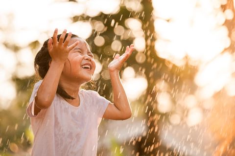 Kleines Mädchen freut sich über Regen