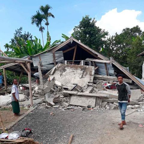 Mann steht vor vom Erdbeben zerstörtem Haus auf der indonesischen Ferieninsel Lombok
