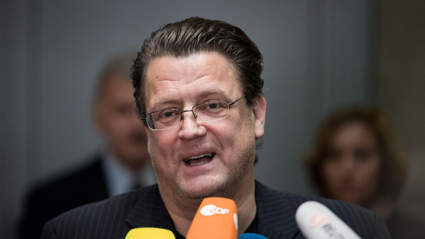 Stephan Brandner, ein Mann mit Brille und zurückgegelten braunen Haaren, spricht in die Mikrofone mehrerer TV-Sender