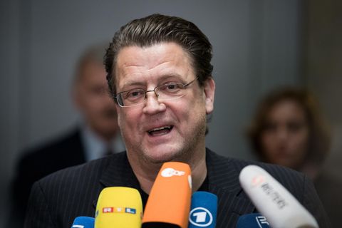 Stephan Brandner, ein Mann mit Brille und zurückgegelten braunen Haaren, spricht in die Mikrofone mehrerer TV-Sender