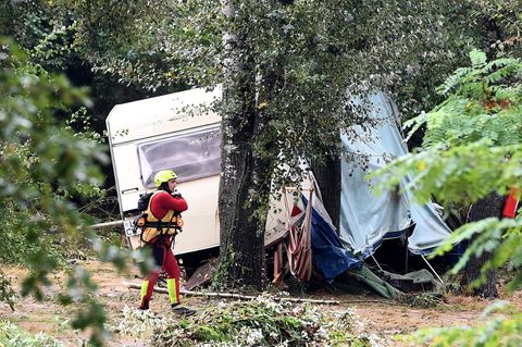 Ein Retter geht an einem bei Überschwemmungen in Saint-Julien-de-Peyrolas zerstörten Wohnwagen vorbei