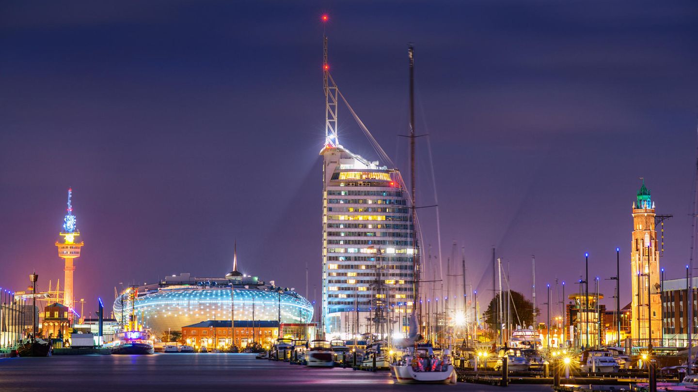 Das neue Bremerhaven bei Nacht: das Klimahaus 8 Grad Ost in Bildmitte und das hohe Hotel Atlantic Sail City rechts daneben.