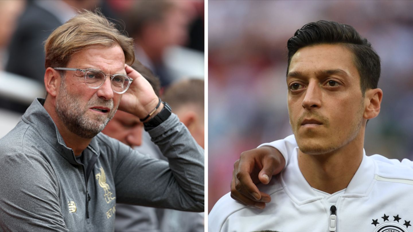 Links sitzt Jürgen Klopp auf einer Trainerbank und streicht sich mit links durchs Haar. Rechts steht Mesut Özil bei der Hymne