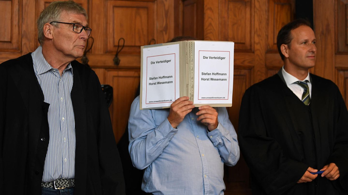 Bremen: Der wegen Mordes Angeklagte hält einen Schnellhefter vor sein Gesicht