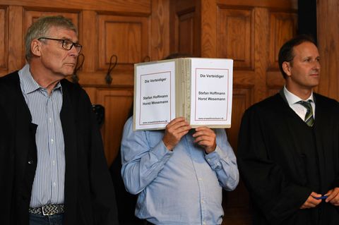 Bremen: Der wegen Mordes Angeklagte hält einen Schnellhefter vor sein Gesicht