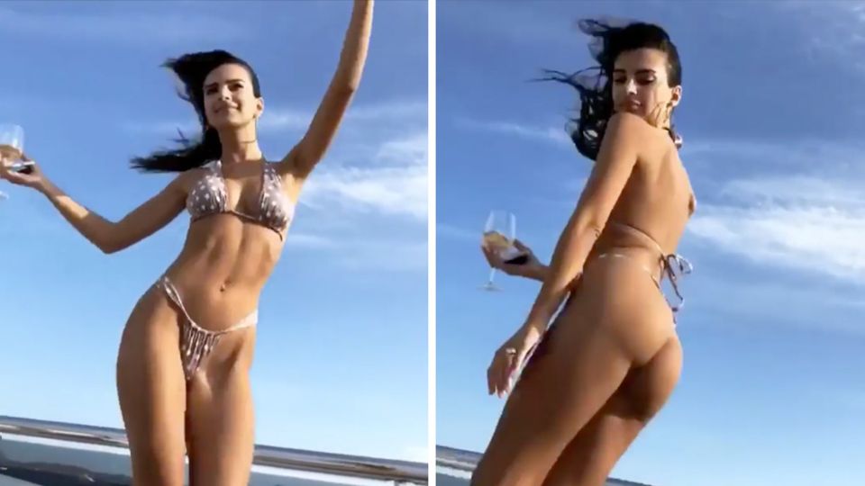 Supermodel Emily Ratajkwoski tanzt im knappen, gepunkteten Bikini auf einer Yacht und hält ein Weinglas in der Hand