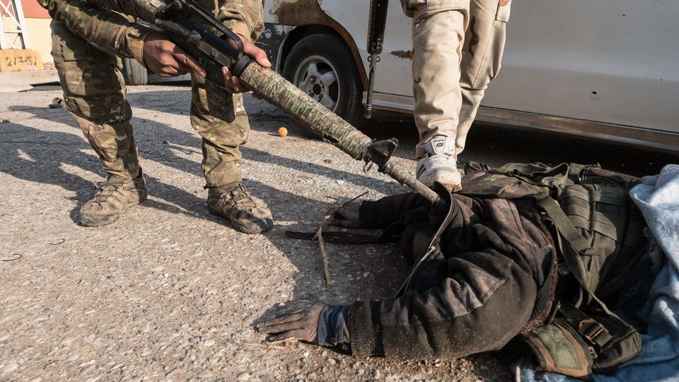 Ein toter Kämpfer der Terrororganisation Islamischer Staat wird von irakischen Soldaten überprüft
