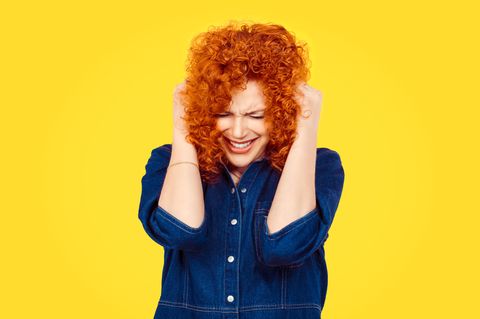 Frau hält sich die Ohren zu