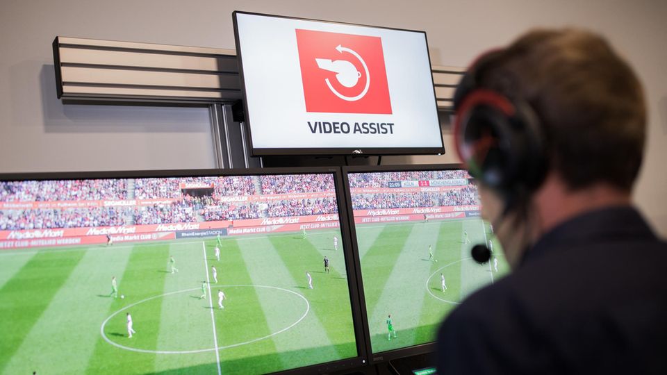 Bundesliga Videobeweis Der Video-Schiedsrichter sitzt vor vier Monitoren auf denen Fußball läuft