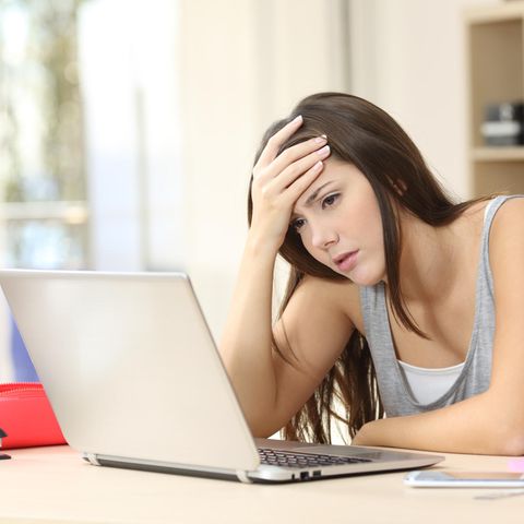 Ein Mädchen sitzt gestresst am Labtop