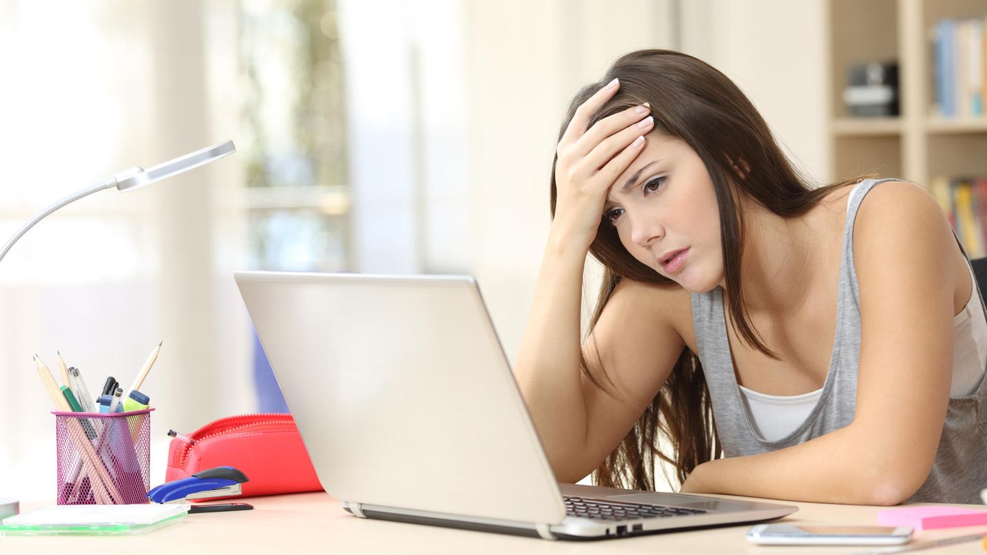 Ein Mädchen sitzt gestresst am Labtop