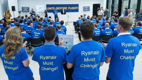 Beschäftigte der Fluggesellschaft Ryanair tragen im Main Airport Center bei einer Demonstration für bessere Arbeitsbedingungen T-Shirts mit der Aufschrift "Ryanair Must Change!"