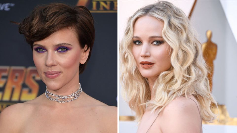 Die Schauspielerinnen Scarlett Johansson und Jennifer Lawrence stehen in schulterfreien Kleidern auf dem roten Teppich
