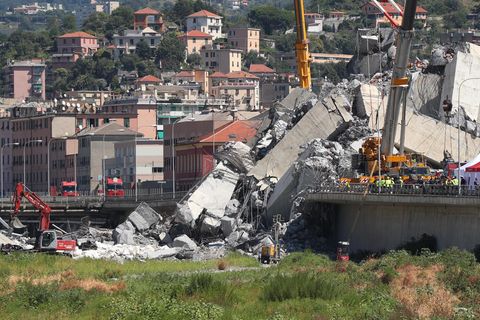 Italien, Genua: Mit Baggern und Kränen werden Trümmerteile einer teilweise eingestürzten Brücke weggeräumt.