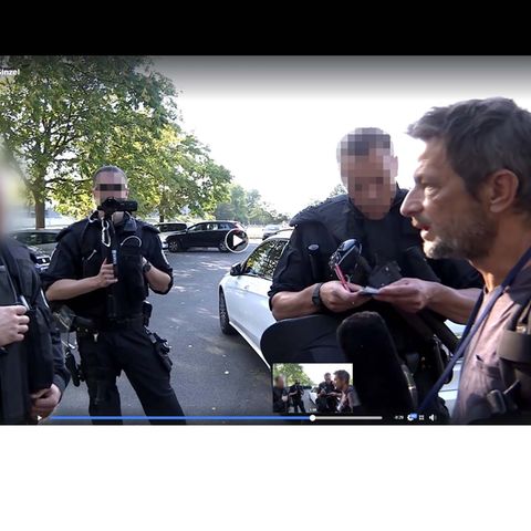 Der freie TV-Journalist Arndt Ginzel diskutiert während einer Pegida-Demo mit Polizisten