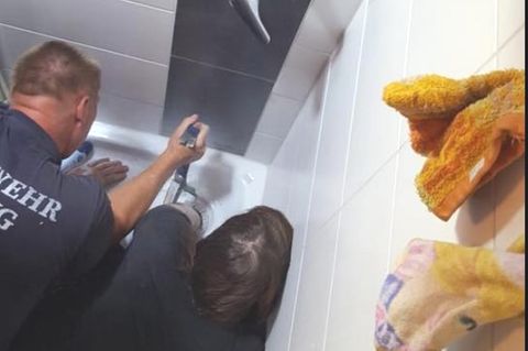 Die Frau steckt im Abflussrohr fest