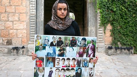 Aschwaq Taloo zeigt vor dem Lalisch-Schrein im Nordirak Bilder von Opfern aus ihrem Dorf