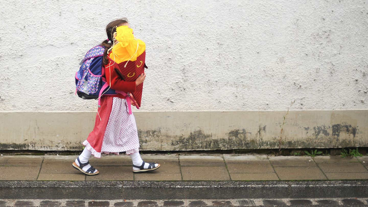 Ein Mädchen geht im Dirndl zu Einschulung