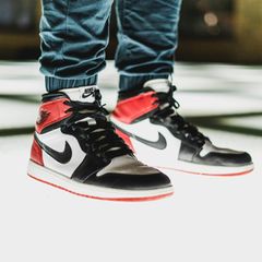 Ein Mann steht in Nike-Schuhen auf einer Glasscheibe, die von unten beleuchtet wird