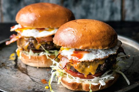 Ein Burger mit Kohl, Salat, Tomate, Fleisch, Bacon und Spiegelei