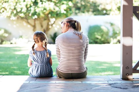 Mutter und Tochter sitzen auf Terasse