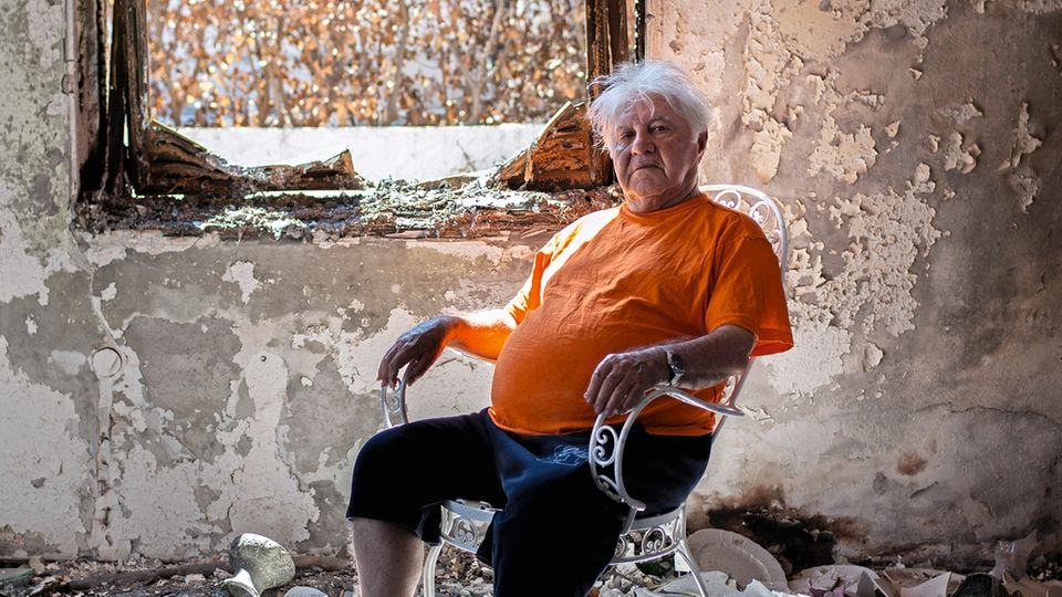 Der pensionierte Ingenieur Athanassios Gantonas, 81, sitzt in der Asche seines Hauses. Die intensive Hitze der Brände in Mati verbog Glas und verwandelte Gantonas' Büchersammlung in weiße Asche