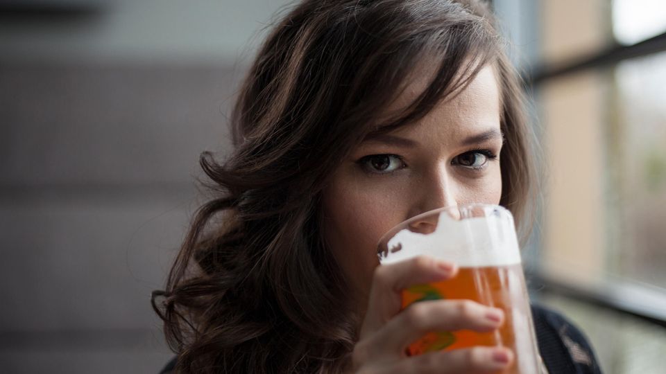 Eine junge Frau trinkt Bier