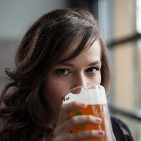 Eine junge Frau trinkt Bier