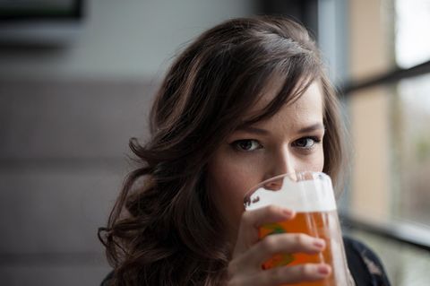 Eine junge Frau trinkt Bier