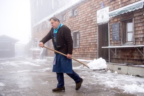 Hüttenwirt Hansjörg Barth schaufelt auf dem Gipfel der Zugspitze Schnee