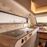 Abgerundete Formen, Induktionsfeld und langes Fenster prägen die Küche.