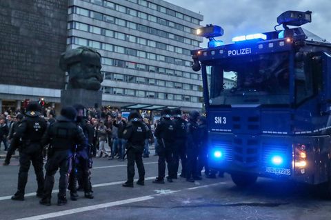 Ein Wasserwerfer und beamte der Polizei am Rande einer Demonstration am Karl-Marx-Monument in Chemnitz