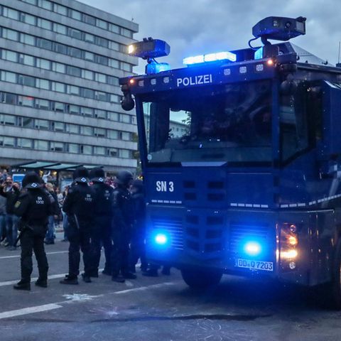 Ein Wasserwerfer und beamte der Polizei am Rande einer Demonstration am Karl-Marx-Monument in Chemnitz